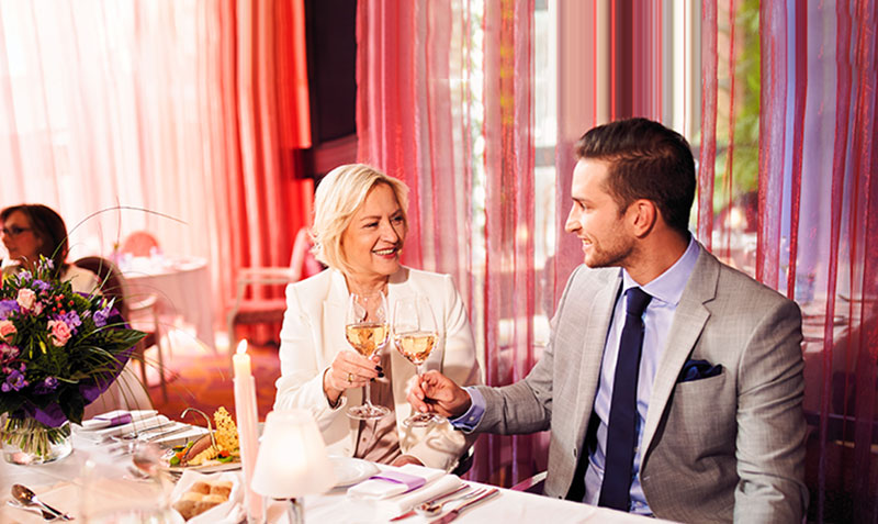Mutter und Sohn stoßen im Restaurant mit Weinglas an