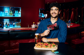 Mann mit Lucky Me Casino Gutschein und ein Glas Bier
